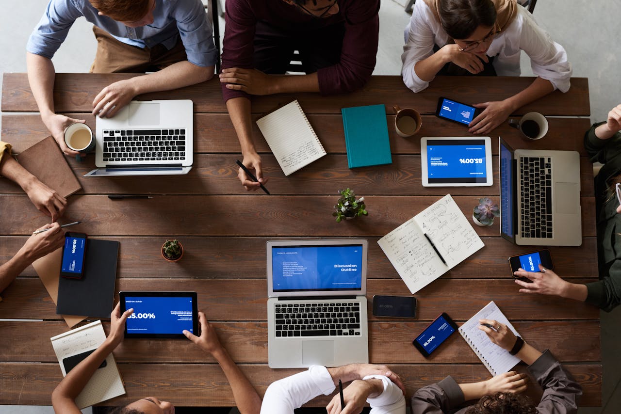 journey-02 Overhead view of a diverse team in a business meeting using laptops and tablets.