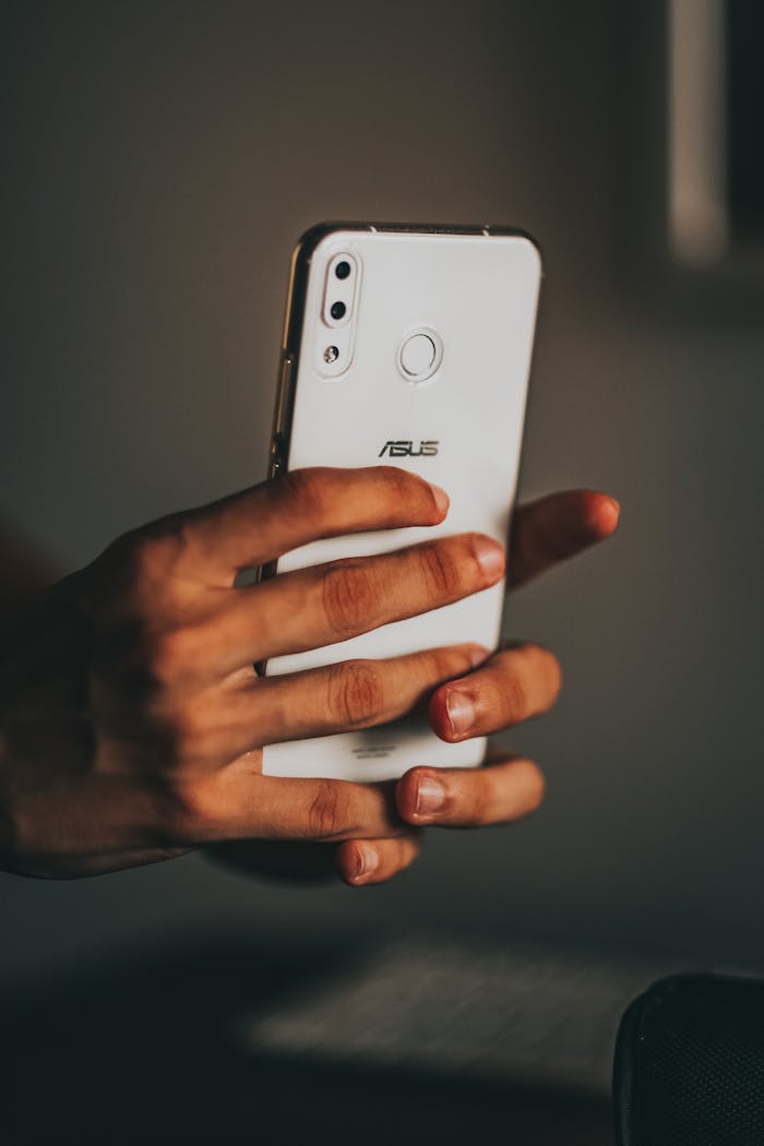 The Art of Drawing Readers In: Your attractive post title goes here Close-up of hands holding a smartphone, focusing on communication technology indoors.
